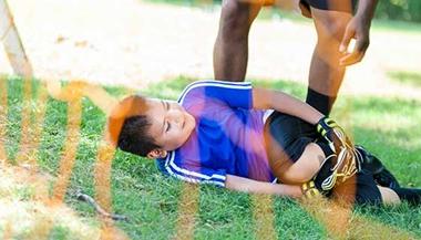 Child with injured knee at soccer game.